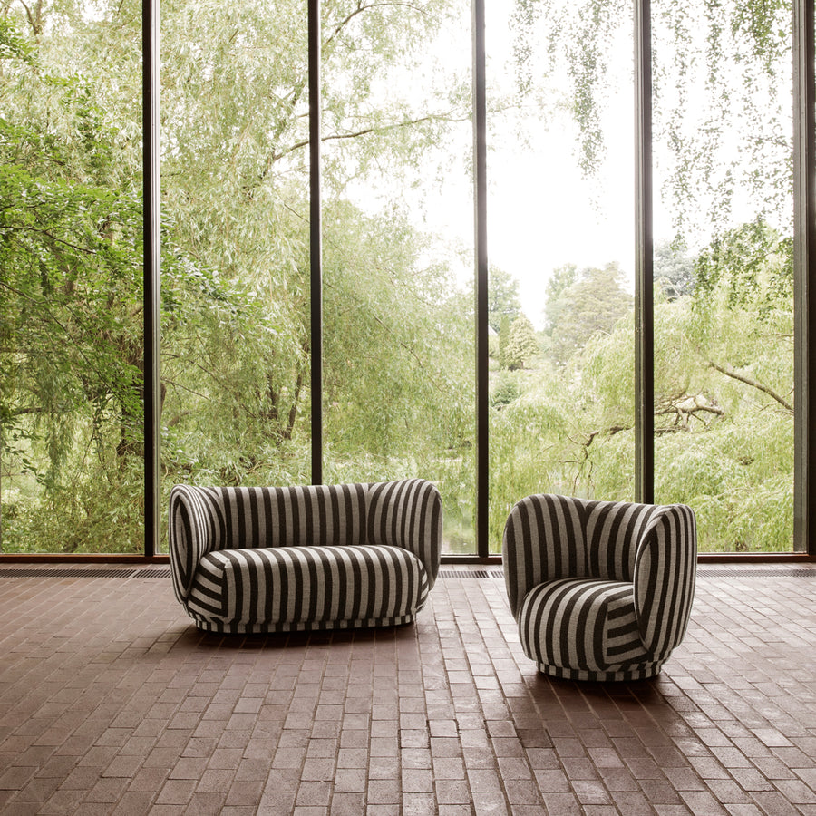 Striped sofa and armchair in a room with large windows showing greenery outside. Ferm Living Rico Lounge Louisiana - Sand/Black