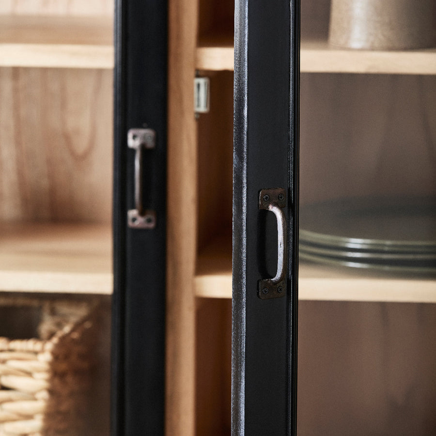 Glass cabinet with black frame and handles on wooden shelves