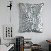 Thumbnail for Room interior with a metallic poster, books, and wooden chairs.