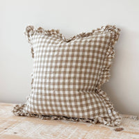 Thumbnail for Checkered pillow with ruffled edges on a wooden surface against a white wall