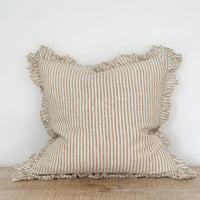 Thumbnail for Striped linen pillow with ruffled edges on a wooden surface against a white wall