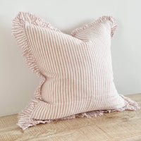 Thumbnail for Pink striped pillow with ruffled edges on a wooden surface against a light background