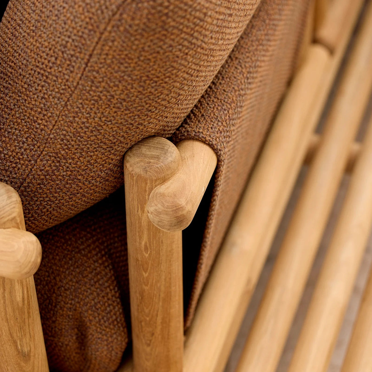 Close-up of a wooden chair with brown fabric