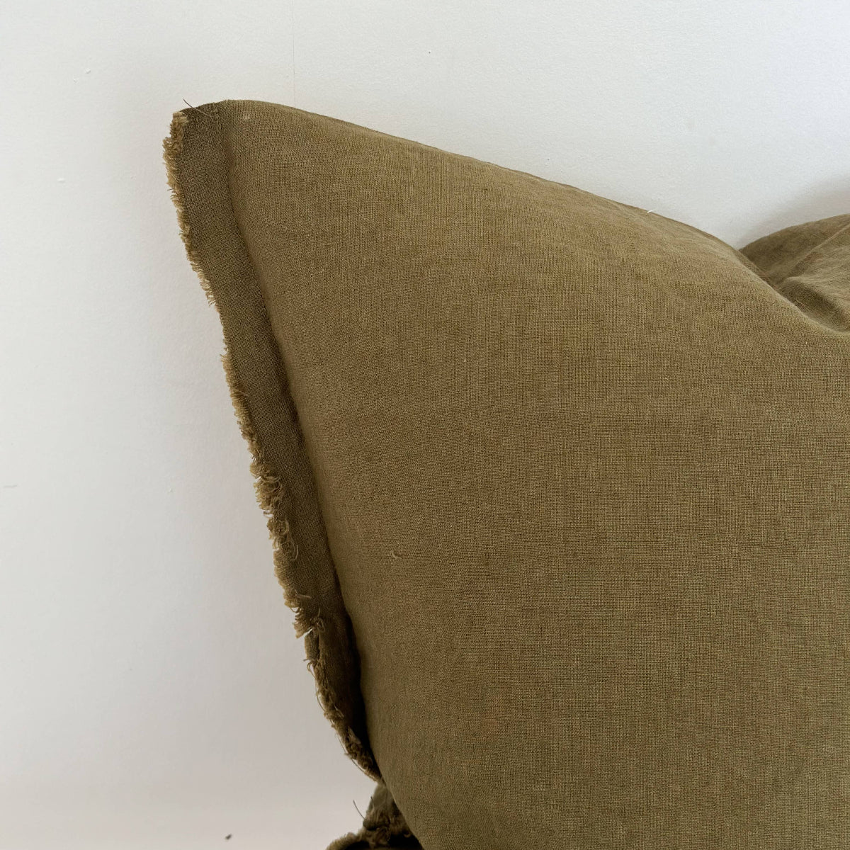 Close-up of a green linen pillow on a white background
