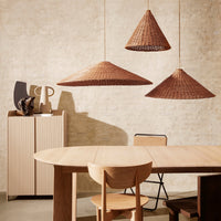 Thumbnail for Ferm Living Dining area with wooden table, chairs, and wicker pendant lights against a textured wall.