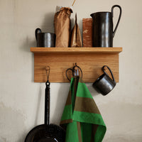 Thumbnail for Wooden shelf with kitchen items including pots, a pitcher, and a green towel on hooks.
