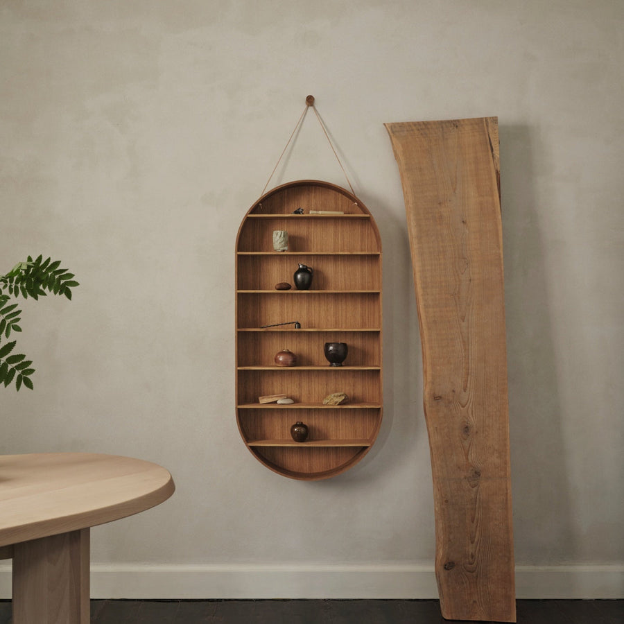 Wooden wall shelf with decorative items against a plain wall.
