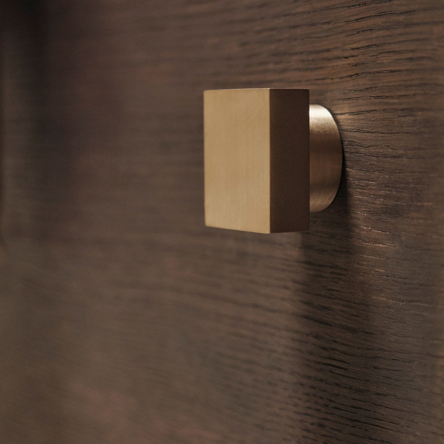 Gold square door handle on a wooden door